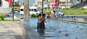 Sıcaktan bunalan çocuklar süs havuzunda serinledi